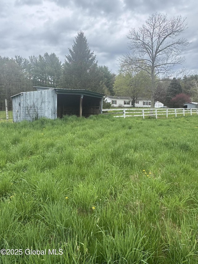 view of yard featuring fence and an outdoor structure