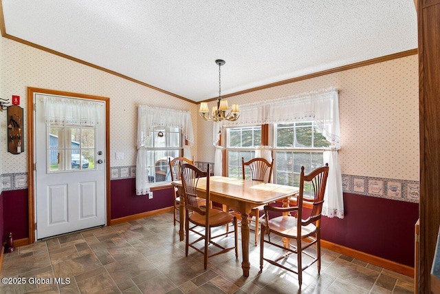dining area featuring a textured ceiling, baseboards, a chandelier, ornamental molding, and wallpapered walls
