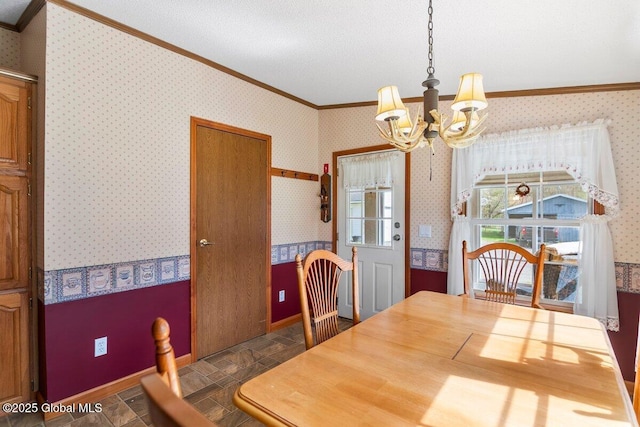 dining area with crown molding, wallpapered walls, a notable chandelier, and stone finish floor