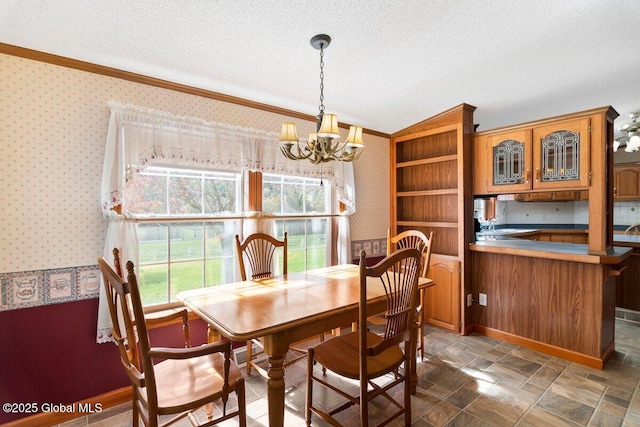 dining room with crown molding, stone finish floor, wallpapered walls, a textured ceiling, and a chandelier