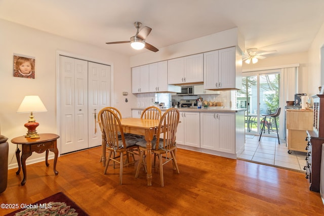 dining area with light wood-style floors and a ceiling fan