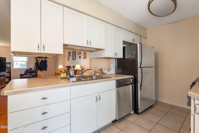 kitchen featuring a sink, appliances with stainless steel finishes, white cabinets, and light countertops
