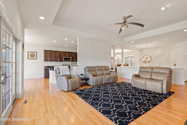 3 Riverside Ct, Stillwater, NY 12170 - living room featuring ceiling fan with notable chandelier, visible vents, recessed lighting, light wood finished floors, and a raised ceiling