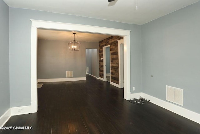 empty room with wood finished floors, baseboards, a chandelier, and ceiling fan