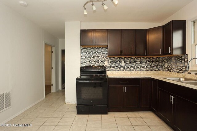 kitchen featuring electric range, a sink, light countertops, and light tile patterned floors