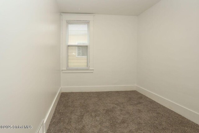 carpeted spare room featuring baseboards