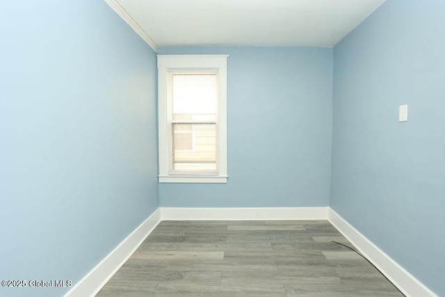 unfurnished room with baseboards and wood finished floors