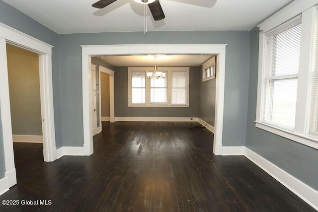 unfurnished dining area with ceiling fan, hardwood / wood-style flooring, baseboards, and a chandelier