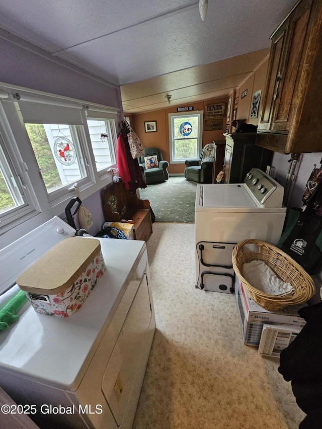 laundry room with a healthy amount of sunlight, carpet, cabinet space, and independent washer and dryer