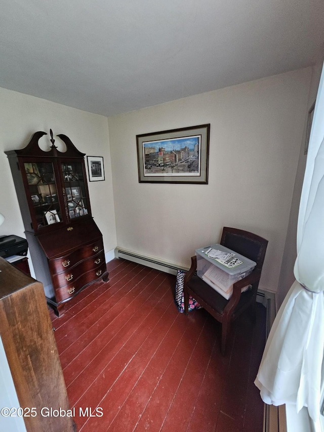 sitting room with baseboards, a baseboard heating unit, and dark wood finished floors