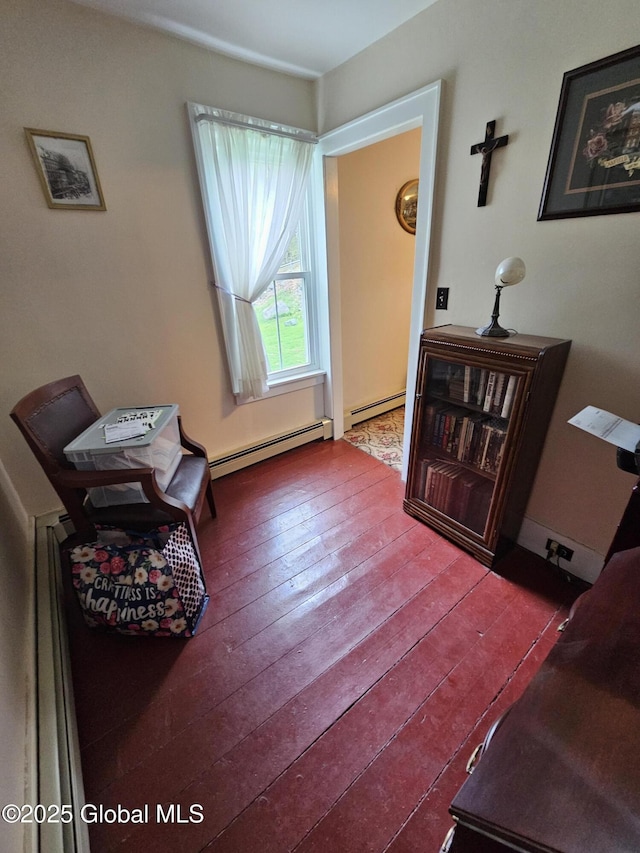 sitting room with dark wood-type flooring and baseboard heating