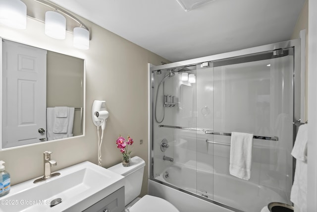 full bath featuring toilet, bath / shower combo with glass door, and vanity