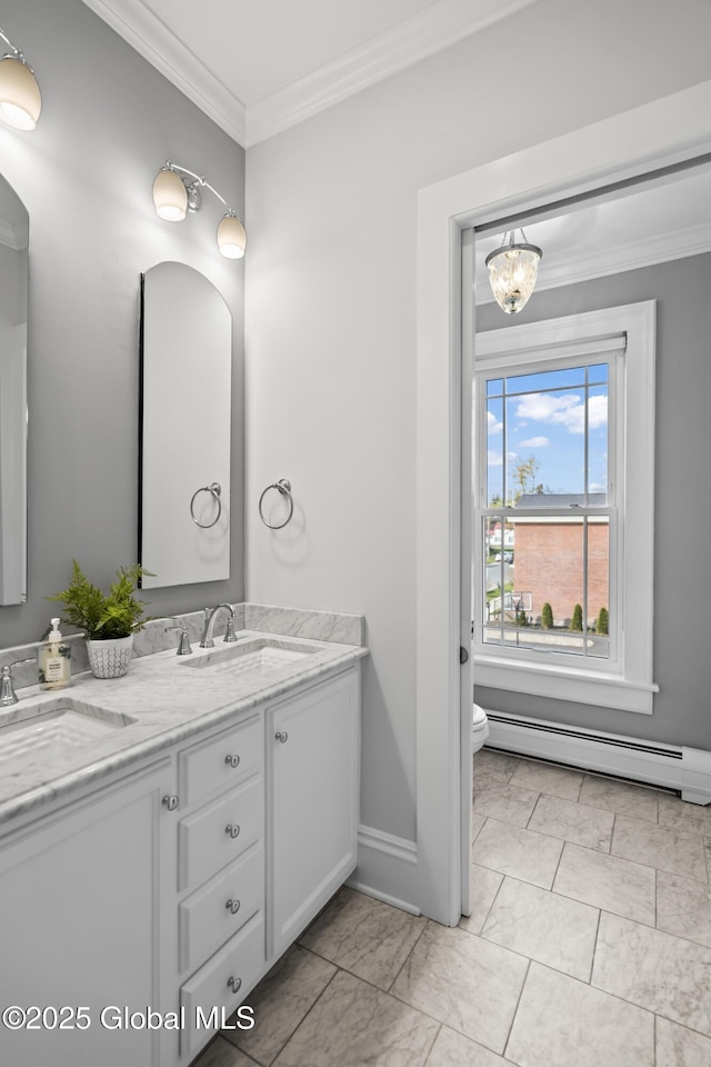 bathroom with a sink, toilet, marble finish floor, a baseboard heating unit, and crown molding