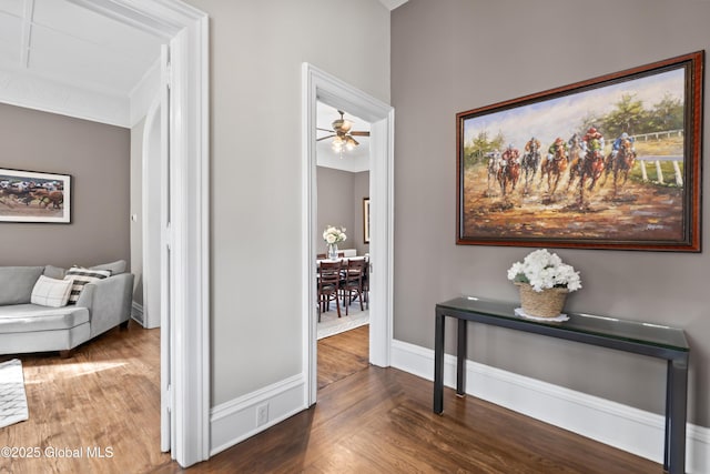 hall with baseboards and wood finished floors