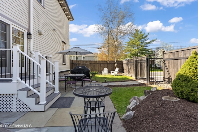 view of yard with a patio, fence, and outdoor dining space
