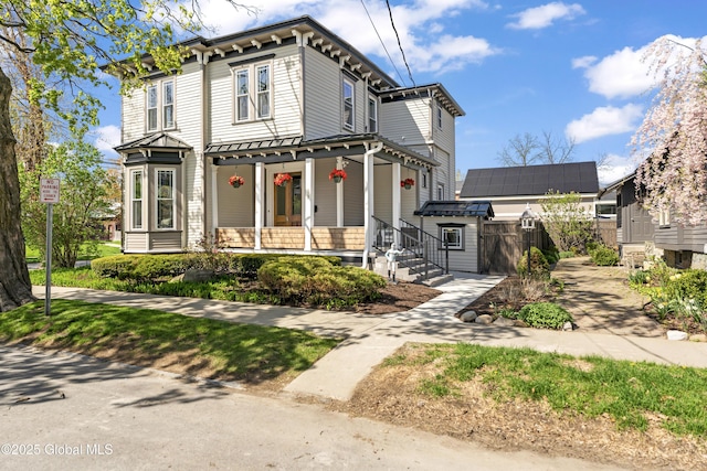 italianate house with a porch and fence