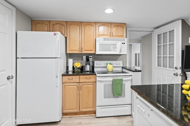 kitchen with recessed lighting, dark stone countertops, light wood finished floors, and white appliances
