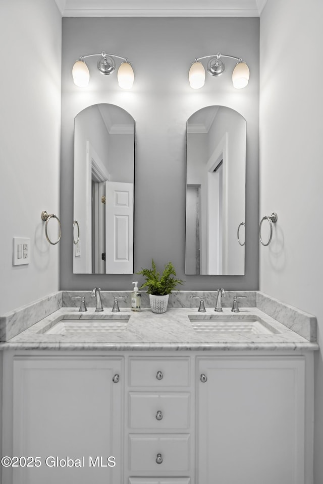 full bathroom featuring ornamental molding, double vanity, and a sink