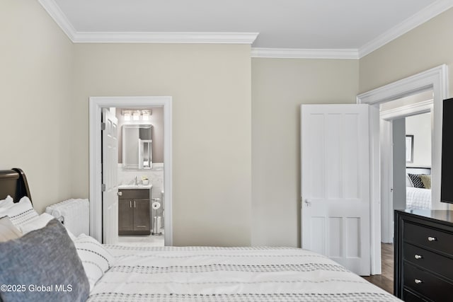 bedroom with a sink, ornamental molding, and wood finished floors