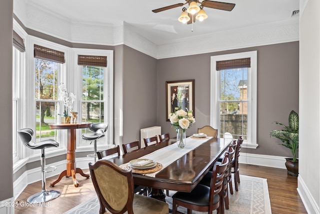 dining area with ceiling fan, ornamental molding, dark wood-style floors, and radiator heating unit