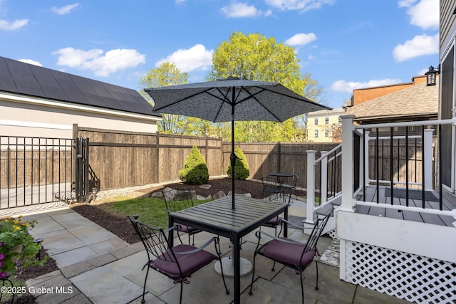 view of patio / terrace featuring outdoor dining space, a fenced backyard, and a gate