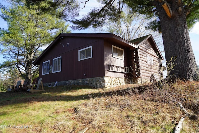 view of property exterior with a lawn and log exterior