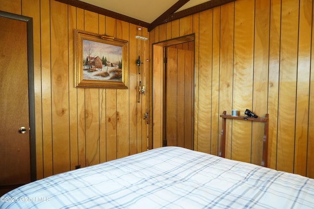 bedroom with wood walls and lofted ceiling