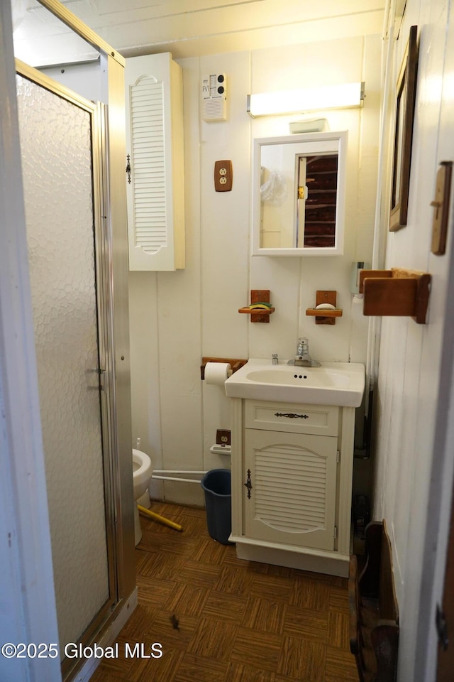 full bath with vanity, a stall shower, and toilet