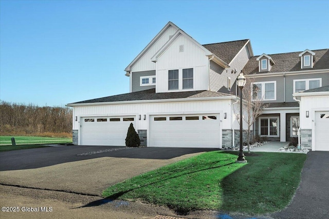 53 Wardley Cir, Colonie, NY 12047 - view of front of house with asphalt driveway, stone siding, board and batten siding, and a front yard