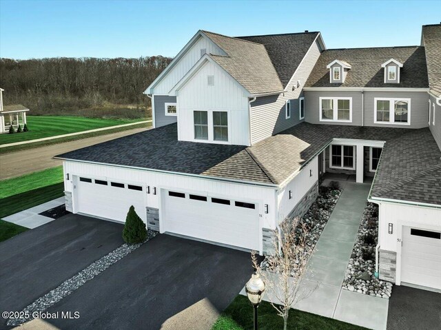 53 Wardley Cir, Colonie, NY 12047 - view of front of home featuring board and batten siding, asphalt driveway, a shingled roof, a garage, and stone siding