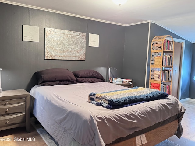 bedroom with crown molding and wood finished floors