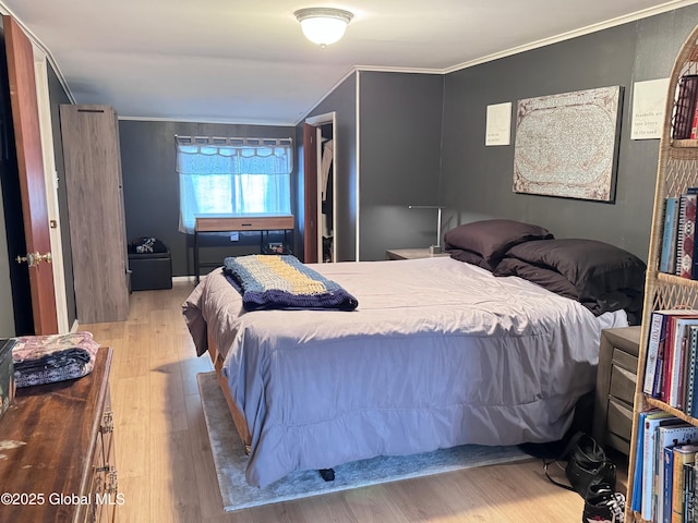 bedroom featuring ornamental molding and wood finished floors