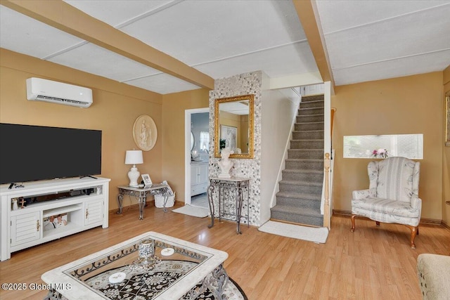 living area featuring stairway, beamed ceiling, a wall unit AC, and wood finished floors