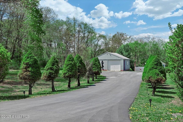 exterior space with an outbuilding, driveway, and a garage