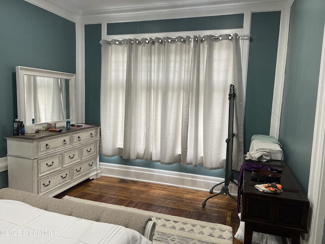 bedroom with crown molding, dark wood-style flooring, and baseboards