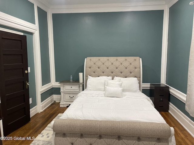bedroom featuring baseboards, dark wood-style flooring, and crown molding