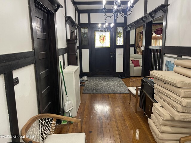 entrance foyer featuring a decorative wall, a chandelier, and hardwood / wood-style flooring