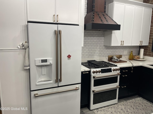 kitchen featuring dark cabinets, white appliances, white cabinets, backsplash, and custom exhaust hood