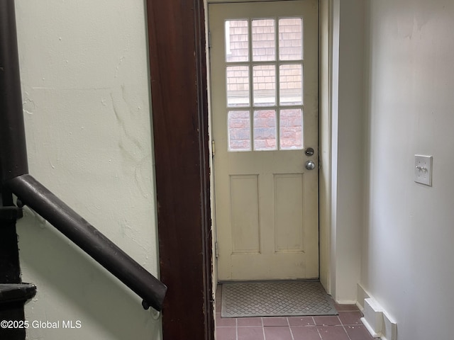 doorway to outside with tile patterned flooring