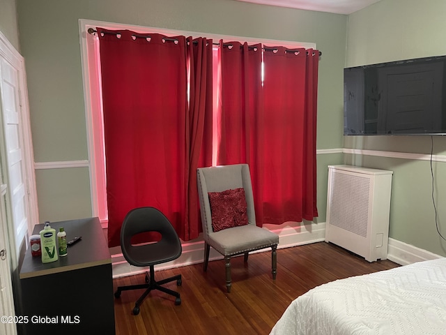 bedroom with wood finished floors and baseboards