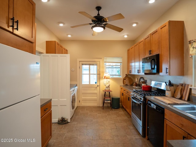 33 Broadway, Rensselaer, NY 12144 - kitchen featuring black appliances, washer / dryer, stone tile floors, dark countertops, and ceiling fan