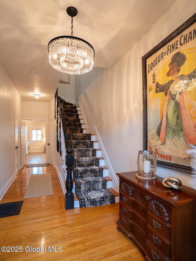 33 Broadway, Rensselaer, NY 12144 - stairs featuring wood finished floors, a chandelier, and baseboards