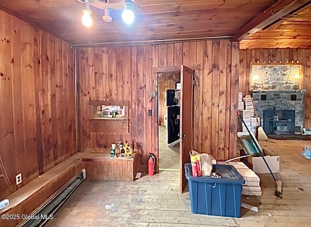 interior space with wood walls, hardwood / wood-style floors, wooden ceiling, and a fireplace