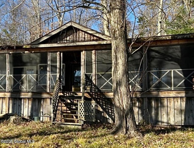 rear view of property featuring stairs