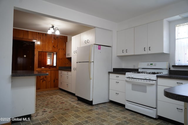 6222 Rte 9n, Hadley, NY 12835 - kitchen featuring white appliances, dark countertops, white cabinetry, wooden walls, and tile patterned floors