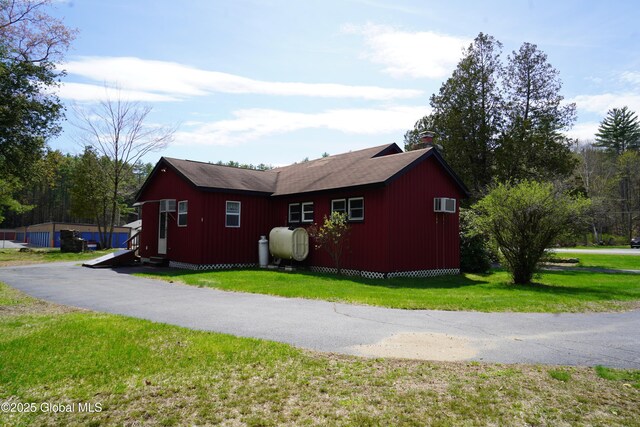 6222 Rte 9n, Hadley, NY 12835 - view of side of home featuring oil tank, a lawn, and a wall mounted air conditioner