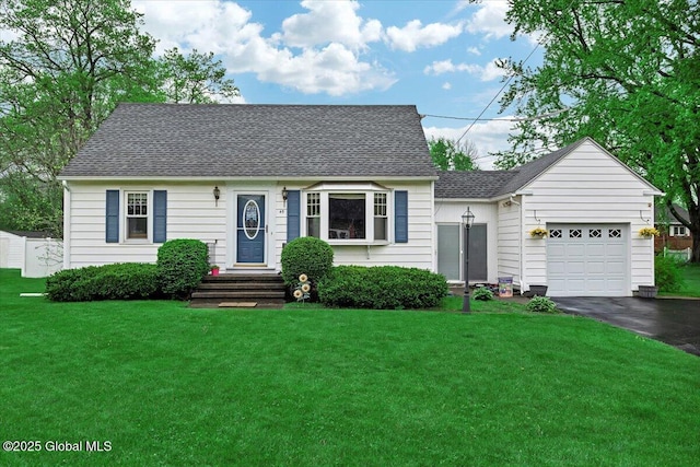 new england style home with asphalt driveway, a garage, a front yard, and a shingled roof