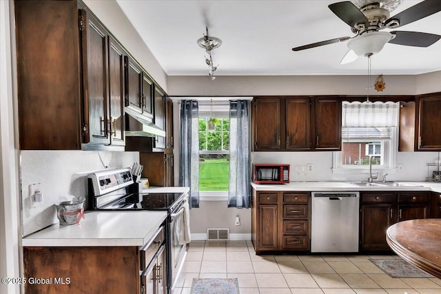 kitchen featuring appliances with stainless steel finishes, a sink, light countertops, and under cabinet range hood