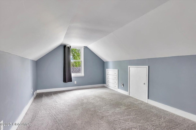 additional living space with carpet floors, vaulted ceiling, and baseboards