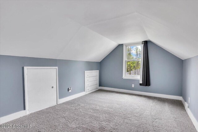 bonus room with carpet flooring, lofted ceiling, and baseboards